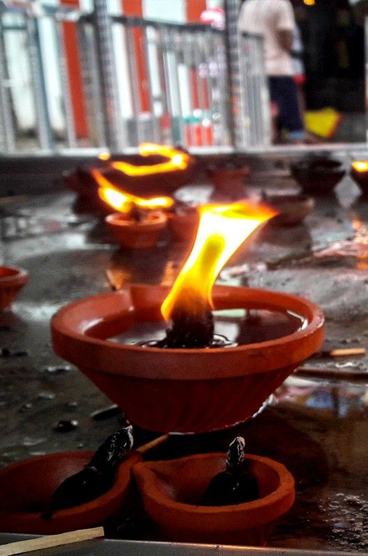 small burning lamp at temple offerings