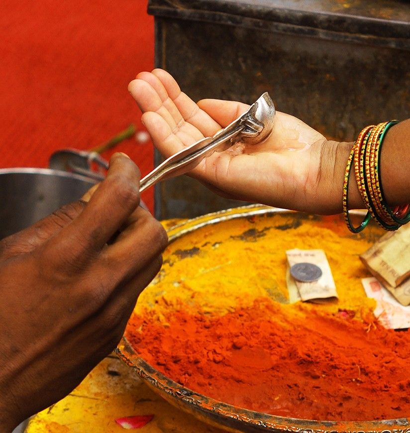 Theertham, the holy water used during the pooja or offering prayers to Hindu god idol, in temple,distributed to devotees.